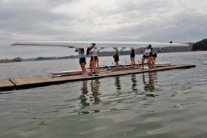 Athletes on the U.S. National Team for women's rowing carry the shell of a boat off the dock after a morning practice on Hartwell Lake in Clemson.
